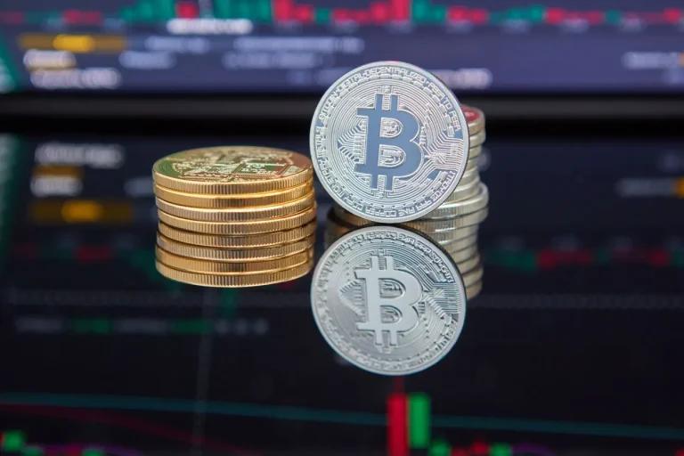 How Stablecoins Move Dollar Liquidity and Bitcoin Moves Into Banking Bitcoin coins stacked in front of a cryptocurrency trading chart